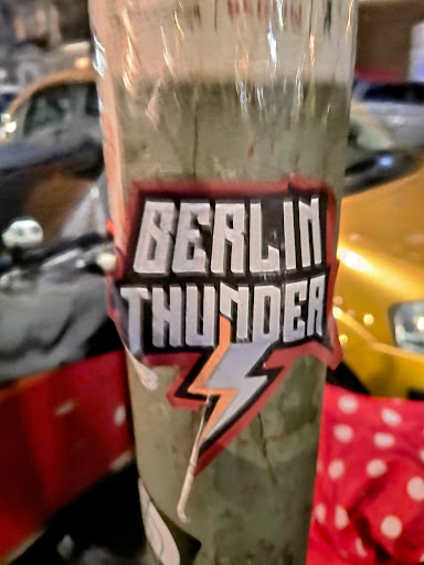 A sticker with the text "Berlin Thunder" and a lightning bolt graphic. The sticker is attached to a pole.