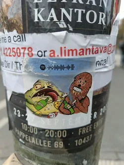 Street sticker A sticker featuring an illustration of Chewbacca from Star Wars and a frog, both appearing to enjoy alcoholic beverages.  The sticker has a Spotify code and the email address a.limantava@... is visible in the background.