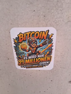 A square sticker with rounded corners depicting a cartoon mascot in a black and orange suit holding a Bitcoin. The design uses vibrant orange, yellow, and blue colors with dynamic lightning and arrow graphics. German text emphasizes the 21 million limit of Bitcoin.