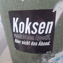 Street sticker A black sticker with white text on it. The text says: "Kokosen verdirbt den Appetit. Aber nicht den Abend." which translates to: "Cocaine spoils the appetite. But not the evening."