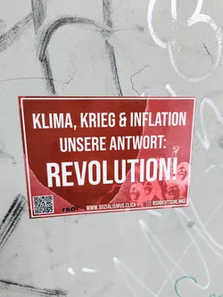 Street sticker A red sticker with white text pasted on a wall. The text reads "Klima, Krieg & Inflation, Unsere Antwort: Revolution!". It also contains a QR code and the social media link to RSOdeutschland's Instagram page.