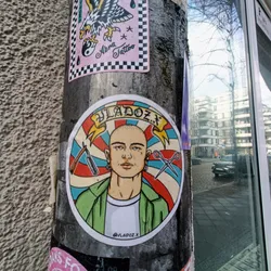 Street sticker A round sticker featuring a stylized illustration of a bald man, possibly a barber, surrounded by barbering tools like a straight razor and scissors. The style is reminiscent of vintage tattoo flash or barbershop pole designs. The artist's Instagram handle is visible at the bottom. 