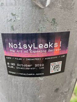 Sticker for an event called NoisyLeaks, which seems to be about exposing secrets.  It lists an expo, films, workshops and a lab. The event took place from the 8th to the 30th of October 2022 at P145, Invalidenstr. 145.  A QR code is included that links to https://noisyleaks.space
