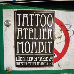 Street sticker Sticker for Tattoo Atelier Moabit located at Lübecker Strasse 24.  The sticker features Art Deco-style typography.