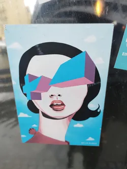 Street sticker A stylish sticker featuring a woman's face with geometric sunglasses. The art style is minimalist and colorful, with a blue and pink color scheme. The background is a simple light blue sky with small clouds.