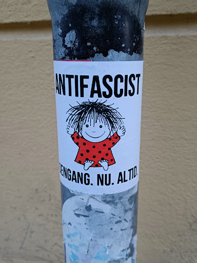 Street sticker A sticker featuring a cartoon child and the word ANTIFASCIST. Below it says 'ENGANG. NU. ALTID.' which translates from Danish to 'Always. Now. Forever.