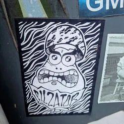 Black and white sticker of a cartoon character with big eyes and a wide open mouth. The character is wearing a helmet and has the word "DILATOR" written below it. The background is made up of wavy lines.