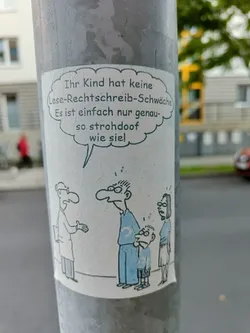 A satirical cartoon sticker depicts a family consulting a doctor. The speech bubble reveals a blunt assessment of the child's literacy struggles. The style is simple, with bold lines and minimalist coloring.