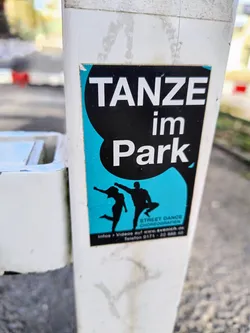 Street sticker A sticker advertising street dance choreographies in the park.  It features a graphic of two dancers and contact information. The text 'TANZE im Park' is prominently displayed.