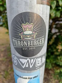Street sticker A round sticker with a burger on a throne. The text 'Thronburger' is written below the image, with 'Est. 2013' underneath.