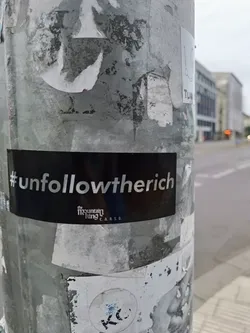 Street sticker A black and white sticker with the text '#unfollowtherich' and a small logo underneath. The logo says 'the mountain king' and 'c.r.s.s.'.