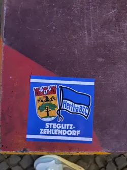 Street sticker This is a Hertha BSC sticker with the Steglitz-Zehlendorf district. It has the coat of arms of Steglitz-Zehlendorf and the Hertha BSC logo on a blue background.