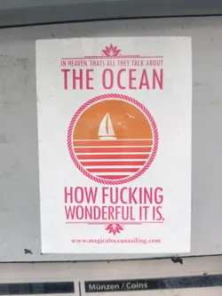 Street sticker A sticker with a minimalist design featuring a sailboat at sunset and a bold statement about the ocean's wonder. It includes a website address, suggesting a connection to a business or brand related to sailing or ocean experiences. The color scheme is primarily white, orange, and pink.