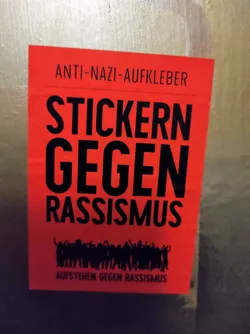 Red and black sticker with the text "Stickern gegen Rassismus" (Stickers against racism) and a row of black silhouettes raising their hands. At the top it says "Anti-Nazi-Aufkleber". At the bottom it says "Aufstehen gegen Rassismus"