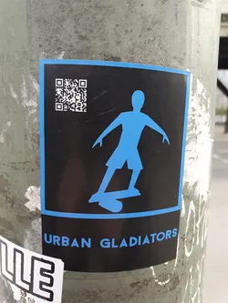 Street sticker A sticker featuring a stylized figure skateboarding, a QR code, and the text 'Urban Gladiators'. The design is predominantly black and blue.