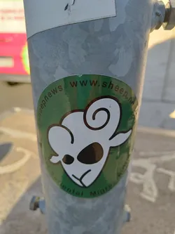 A green and white sticker with an illustration of a sheep and the text "www.sheepnews.com" and "Environmental Migration".