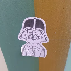Street sticker A sticker featuring a stylized illustration of Darth Vader wearing a collared shirt. The art style is simple and minimalist, with the focus on the character's iconic helmet and the contrast between the dark helmet and light clothing.