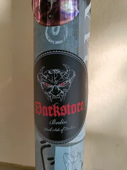 Street sticker A black and red sticker with a devilish face and the text "Darkstore Berlin" written in a gothic style font.  The tagline "Dark Side of Fashion" is written below. 