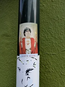 The sticker features an image of Diego Maradona depicted as a religious figure, complete with a halo and a red robe, and the text "Santo Diego".