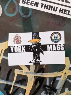 Street sticker Rectangular black-and-white sticker featuring a cartoon magpie mascot in a suit. Flanked by the York coat of arms and Newcastle United crest, with 'YORK MAGS' text.