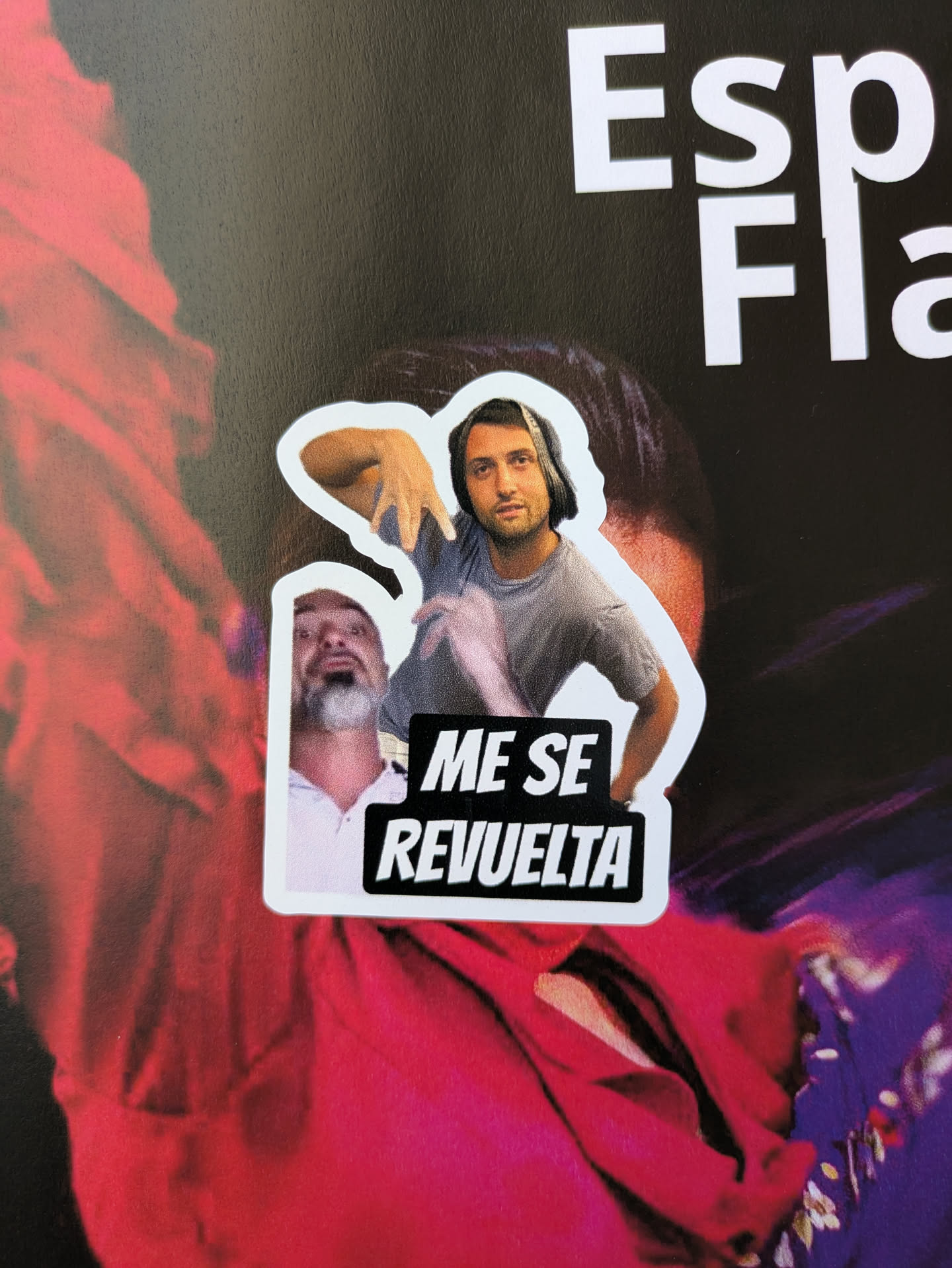 This sticker shows one man on top wearing headphones and another below. The text on the sticker reads "ME SE REVUELTA".