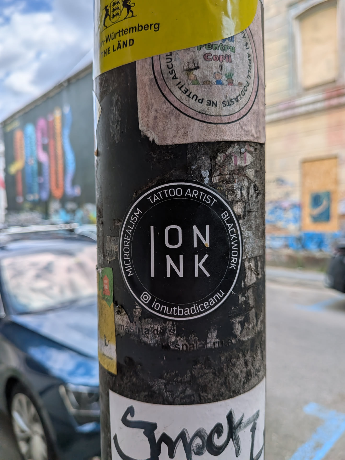 A round black sticker with white text. The center displays 'ION INK' stylized with a vertical bar. The outer border contains the text 'MICROREALISM TATTOO ARTIST BLACKWORK' and an Instagram handle at the bottom.