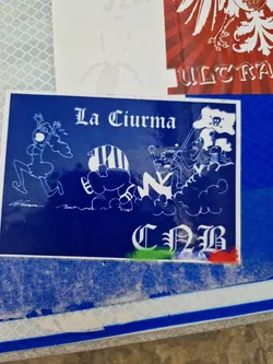 Street sticker A blue sticker with a cartoon illustration of a crew, possibly pirates, with a pirate flag. The text \"La Ciurma\" is visible at the top and \"CNB\" at the bottom. The style is reminiscent of punk or street art.
