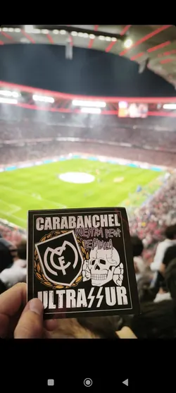 Street sticker A rectangular sticker with a black background featuring a bold, aggressive design. On the left, a stylized Real Madrid C.F. crest is encircled by a golden/yellow laurel wreath. To its right, a white skull with prominent teeth and bone elements is depicted. Above these central elements, the word 'CARABANCHEL' is written in white, blocky capital letters. Below 'CARABANCHEL' and between the crest and skull, the phrase 'VUESTRA PEOR PESADILLA' (Your worst nightmare) is written in a smaller, purple-pinkish font. At the bottom, 'ULTRASUR' is prominently displayed in large, white, blocky capital letters, with two lightning bolt symbols replacing the 'S's.