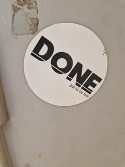 Street sticker A round white sticker with the word \"DONE\" in bold black letters. Underneath, it says \"got to be real\".