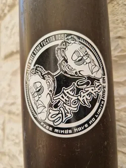 Black and white sticker with two stylized faces and text. The text on the sticker says "Let's make some fucking noise", "The Stickers", "Free minds have no limits", and "Rave on".