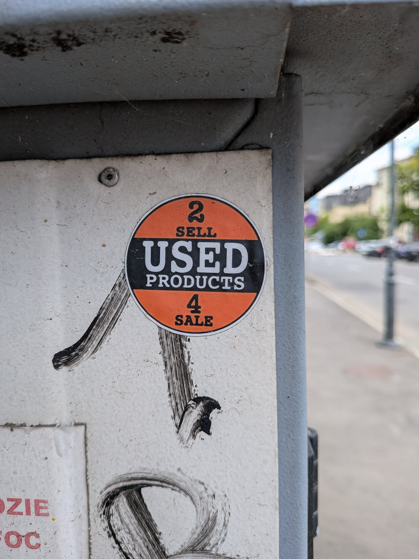 A round sticker divided into three horizontal sections. The top and bottom sections are orange with black text reading '2 SELL' and '4 SALE'. The middle section is a black band containing the white text 'USED PRODUCTS'.