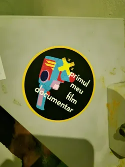 Street sticker Round sticker with a illustrated camera and text in portuguese. The text says: "meu primeiro filme documentar" which means in english: "my first documentary film"