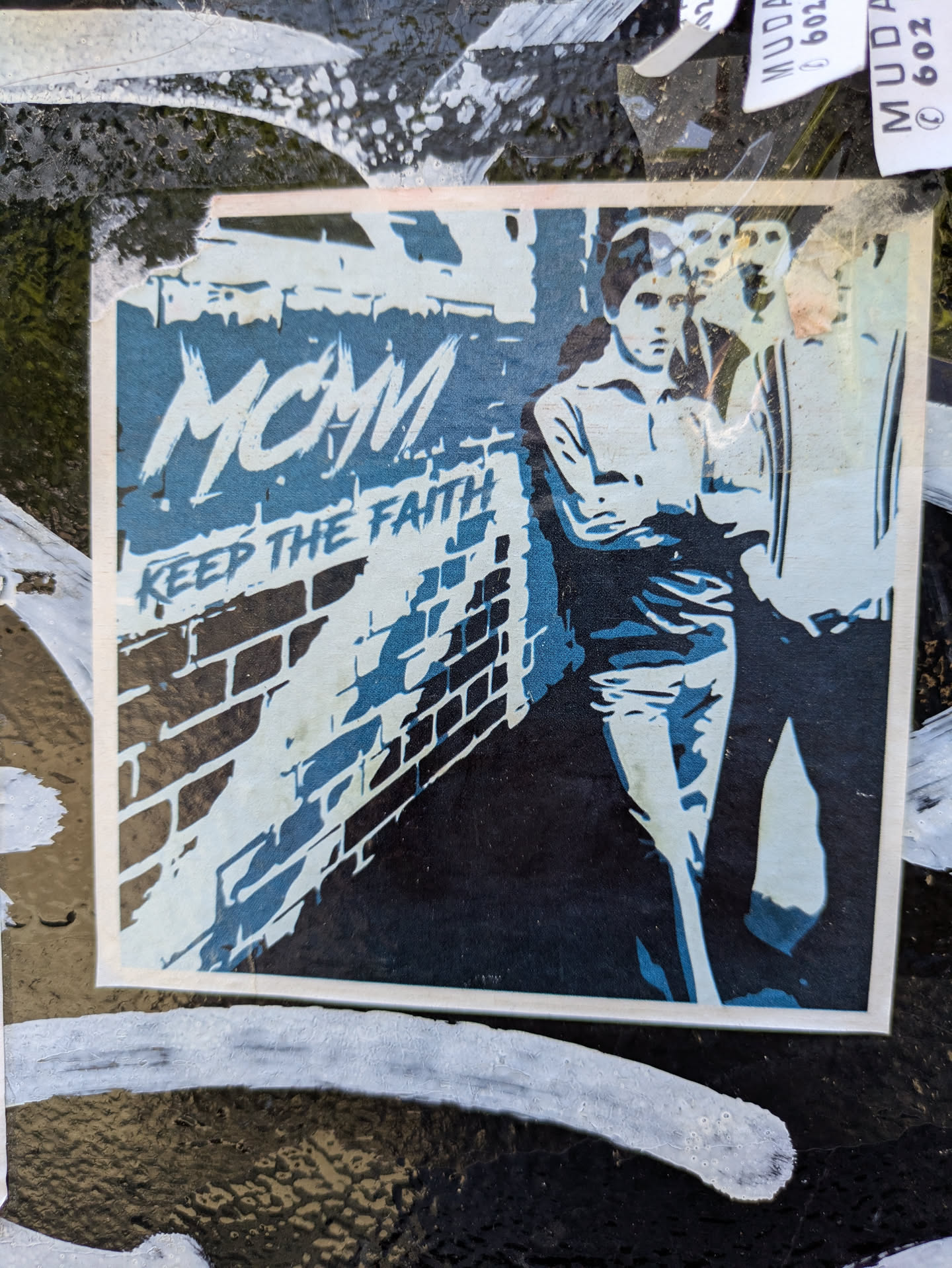 A sticker featuring a black and white image of a group of men with the text "MCM KEEP THE FAITH".