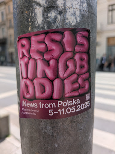 This sticker on a pole announces the 'Resisting Bodies' festival. The title is written in a bubbly, three-dimensional font. The sticker also mentions 'News from Polska' and provides the dates May 5-11, 2025. A QR code is present in the bottom right corner.