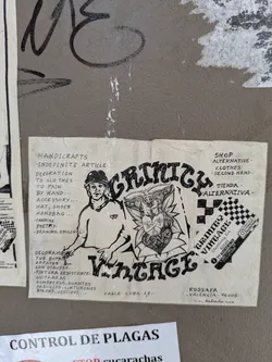 Street sticker This is a vintage-style sticker for Grinich Vintage, a clothing company. The sticker features a hand-drawn illustration with the company name, a drawing of a man with a cap and a faun, and the text "Shop alternative, Clothes, Second Hand". The sticker also includes the company's address in Russafa, Valencia, and a small checkered label saying to follow them on Instagram.