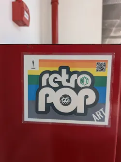 Street sticker A rectangular sticker featuring the stylized text 'retro pop' in white with a dark outline. The background consists of horizontal rainbow stripes. It includes a pixelated alien icon, a green 'NFT' hexagon, a QR code in the top right, and 'töyopü' branding in the top left.