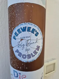 Street sticker A worn sticker from Peewee's Big Band's 2021 Italy tour.  The sticker is circular with text and shows some damage from wear and tear.