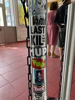 Street sticker A sticker featuring bold black text that reads 'LAST KIL' with the smaller text '93 VMD TNZ' stacked vertically on the right side, affixed to a metal post.