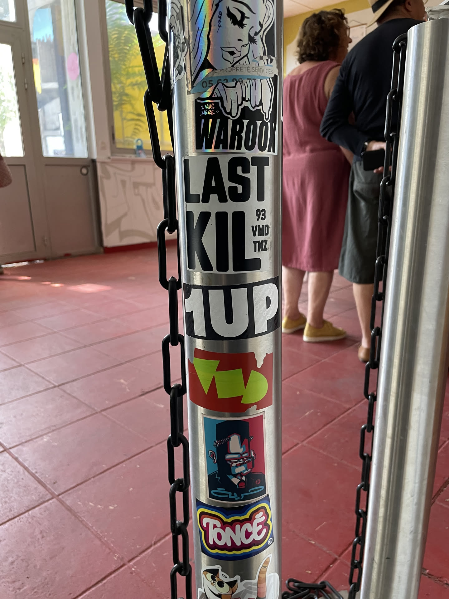 A sticker featuring bold black text that reads 'LAST KIL' with the smaller text '93 VMD TNZ' stacked vertically on the right side, affixed to a metal post.