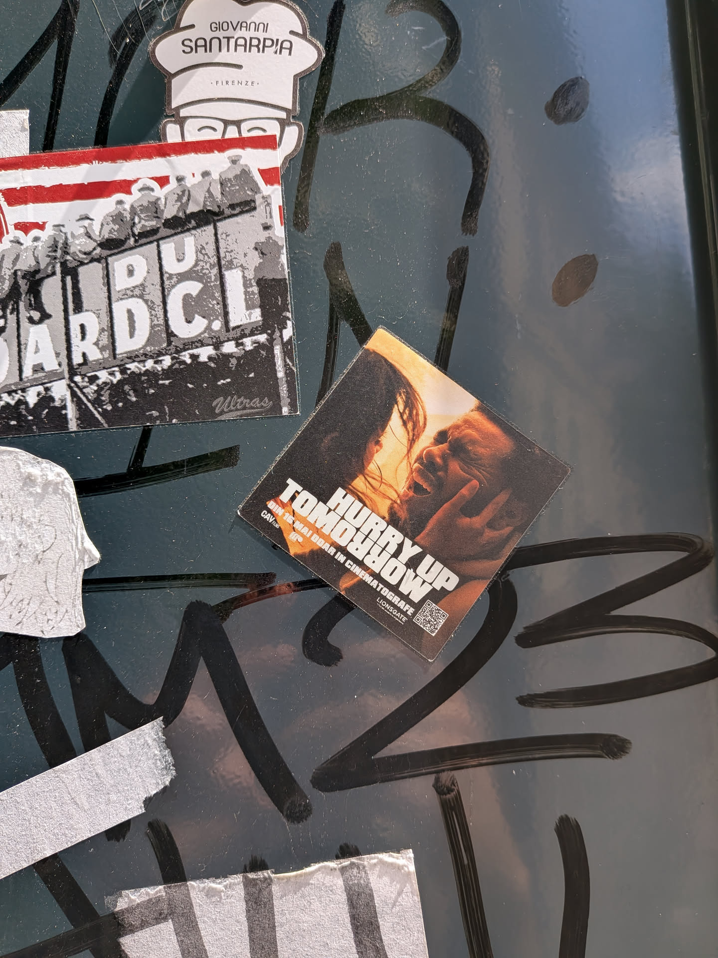 A square, tilted sticker depicting a warm-toned, intimate close-up of a couple. It features the bold white title 'HURRY UP TOMORROW' and Romanian promotional text 'DIN 16 MAI DOAR IN CINEMATOGRAFE' at the bottom, alongside studio logos and a small QR code.
