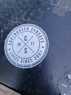 Street sticker A round sticker with the text "Copenhagen Sundays" in a circular design. In the center, there is a logo with a "C" and an "S" crossed, and the numbers "20" and "01" on either side.  The text "Loyal Since 2001" is also visible at the bottom.