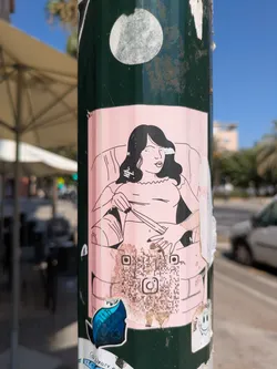 Street sticker A pink sticker adhered to a green pole features a black and white line drawing of a woman sitting in a chair. The drawing style is simple and somewhat cartoonish.  A QR code is located towards the bottom of the sticker, along with what appears to be an Instagram logo. The sticker is peeling and shows signs of wear.