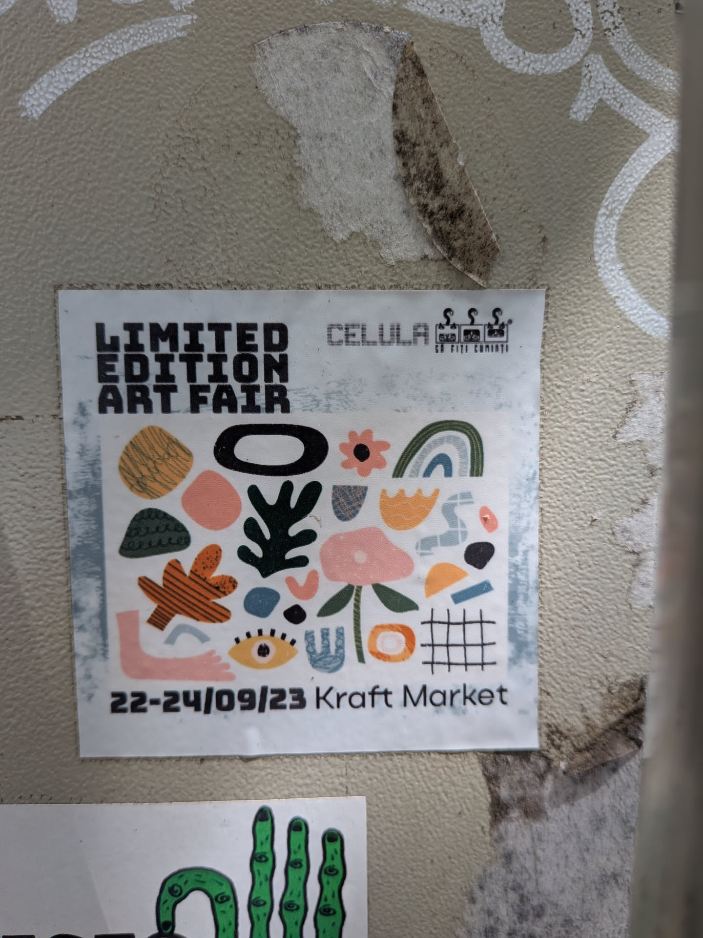 A square white sticker featuring a collage of colorful abstract shapes, organic forms, and illustrations like an eye, a flower, and a rainbow. Text at the top reads 'LIMITED EDITION ART FAIR' and 'CELULA', while the bottom displays the dates '22-24/09/23 Kraft Market'.