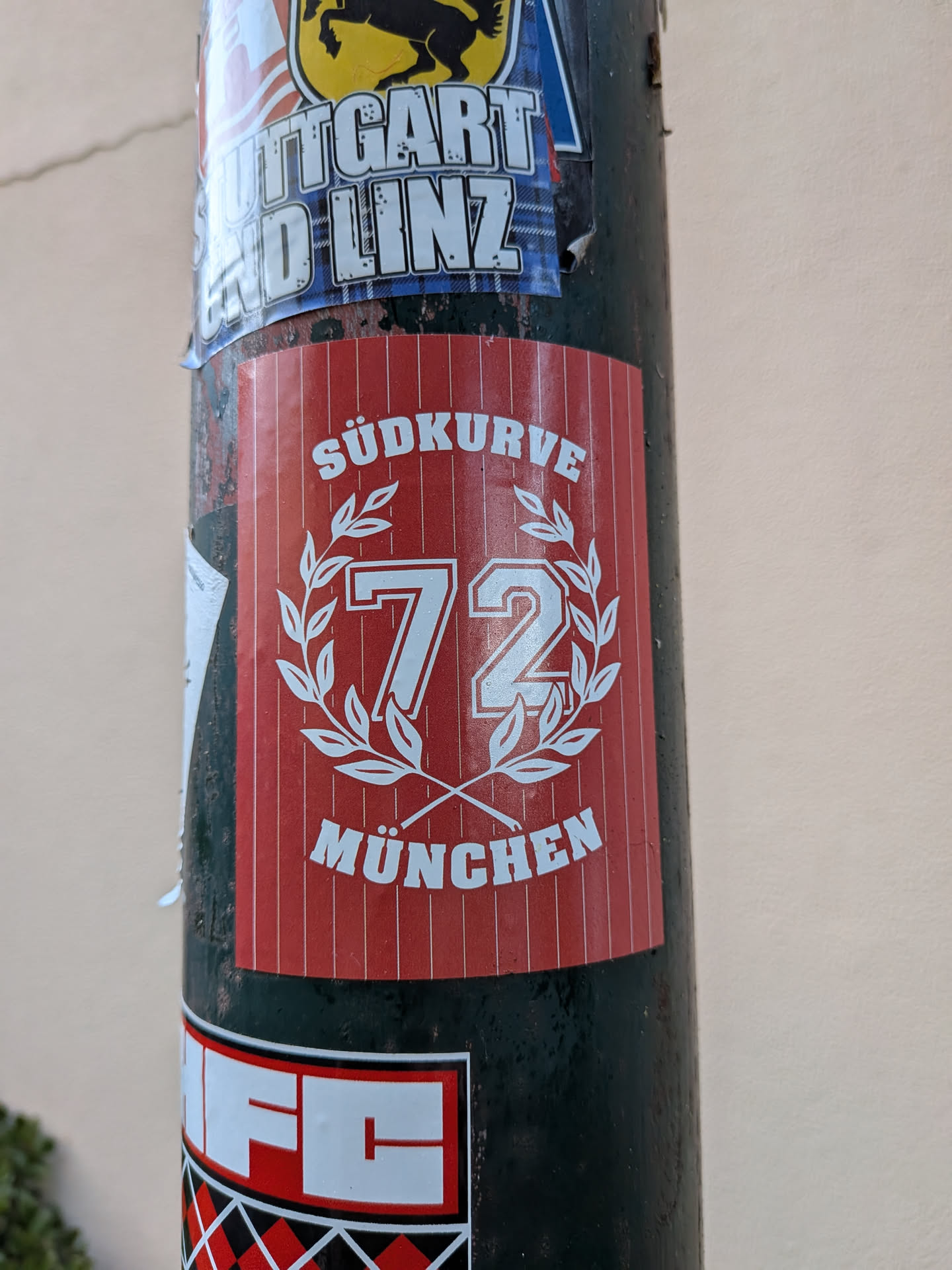 A rectangular red sticker with white pinstripes, featuring the text 'SÜDKURVE' and 'MÜNCHEN' surrounding a central '72' inside a laurel wreath.