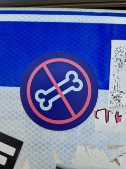 Round sticker with a blue background and a pink circle in the middle. The pink circle has a line across a bone image, symbolizing a prohibition.