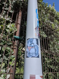 Street sticker Rectangular sticker depicting a stylized blue cartoon bird with a large pink beak and wide eyes, set against a dark background with a graffiti signature at the bottom.
