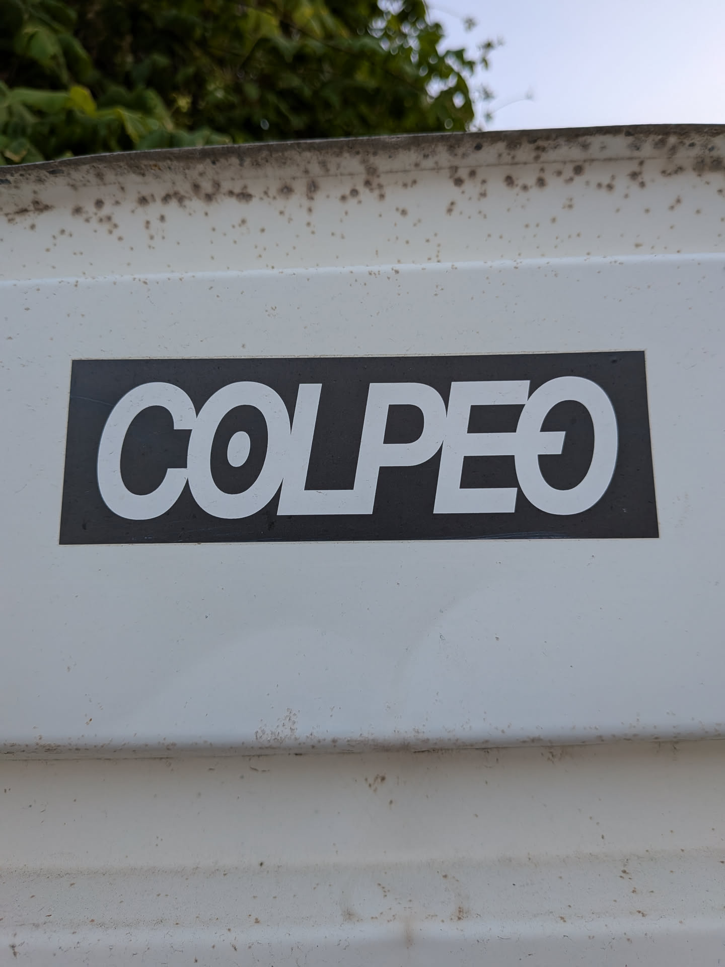 A rectangular black sticker featuring the word 'COLPEO' in bold white sans-serif font. The letters are closely kerned, and the final 'O' contains a horizontal line through the middle.