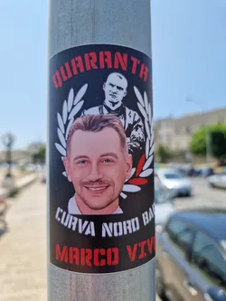 Street sticker A sticker featuring a portrait of Marco, with the text "QUARANTA" at the top, "CURVA NORD BARI" at the bottom, and a laurel wreath.  Another person is in the background.  The words "MARCO VIVO" are also present, suggesting a tribute.