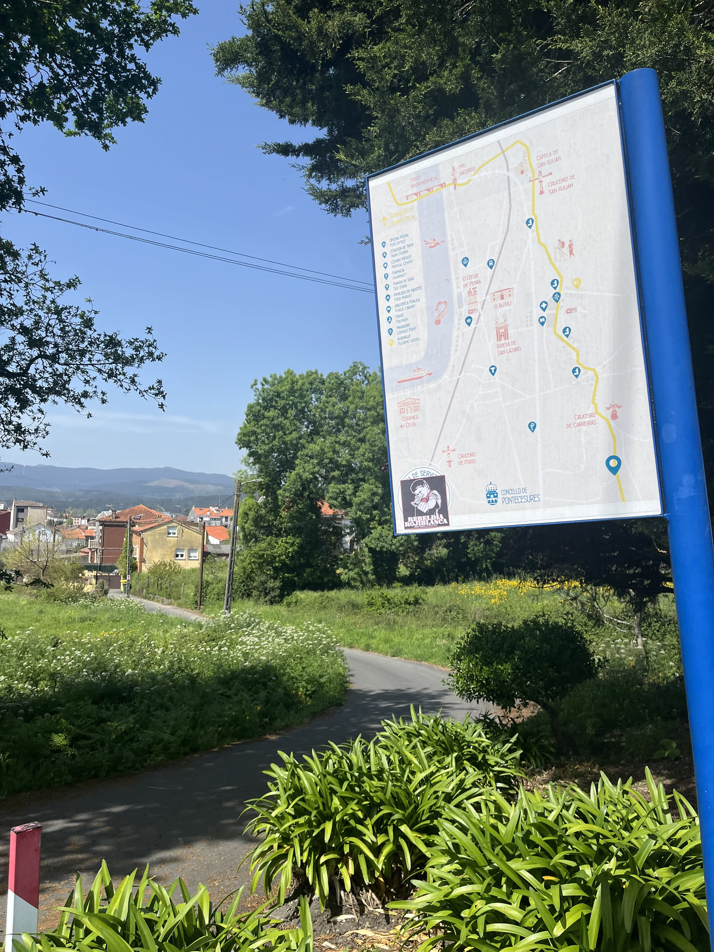 The sticker is square-shaped with a black border, featuring a stylized, somewhat aggressive figure in profile, facing left. The figure has a dark, possibly black, face with a white outline, wearing a red bandana over their mouth and nose. A white eye is visible. The figure's left arm is raised, forming a fist, also in black with a white outline. Below the figure, in a white banner with a black outline, is the text "REBELIÓN ROJIBLANCA" in black capital letters. The overall color scheme is stark black, white, and red, with the background of the figure being white.