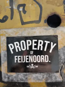 Street sticker A rectangular black sticker featuring bold white sans-serif text that reads 'PROPERTY OF FEIJENOORD.' At the bottom center, a small white skull and crossed cutlasses emblem is flanked by 'FRFC' and '1908'.